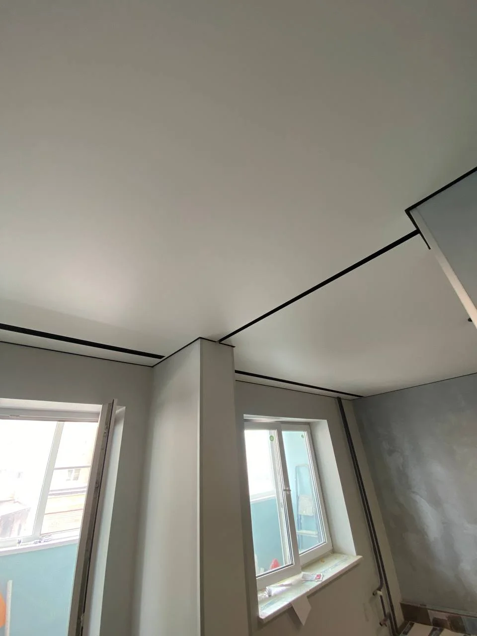Матовый натяжной потолок со скрытыми карнизами и черной вставкой в квартиру