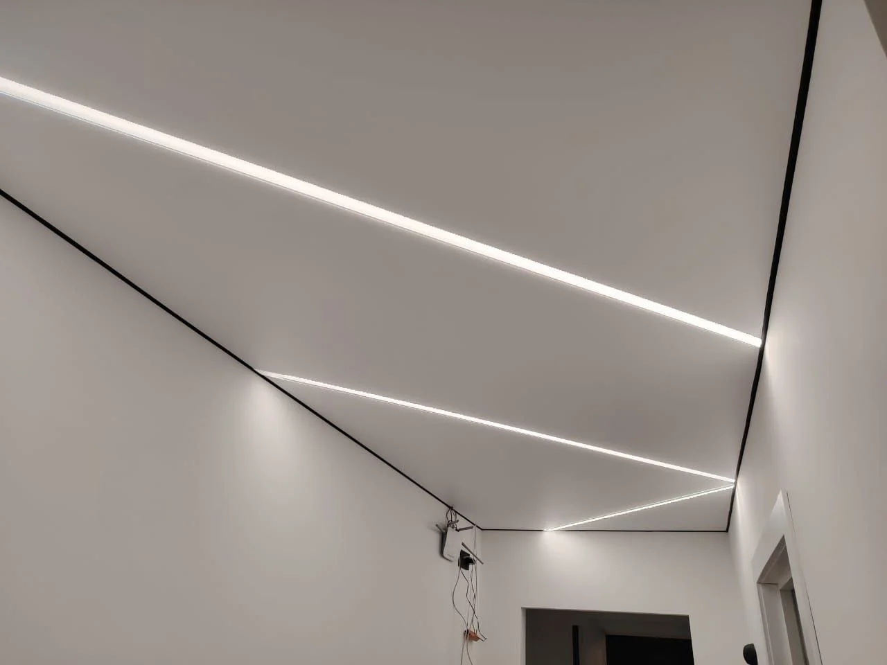 Матовый натяжной потолок со световыми линиями и черной вставкой в прихожей