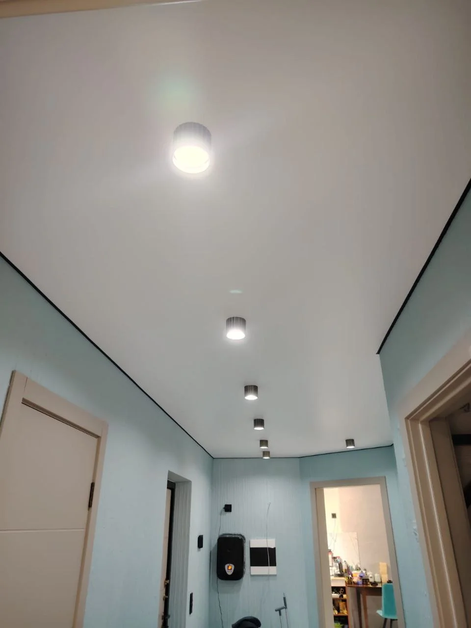 Матовый натяжной потолок для прихожей с накладными точечными светильниками и черной вставкой