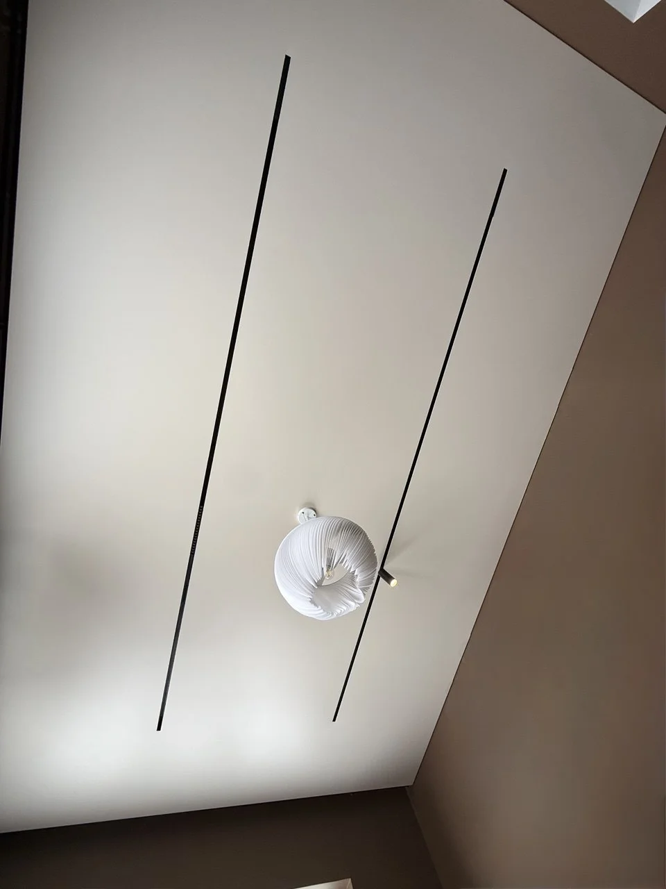 Натяжной потолок для коммерческого помещения с треками и люстрой